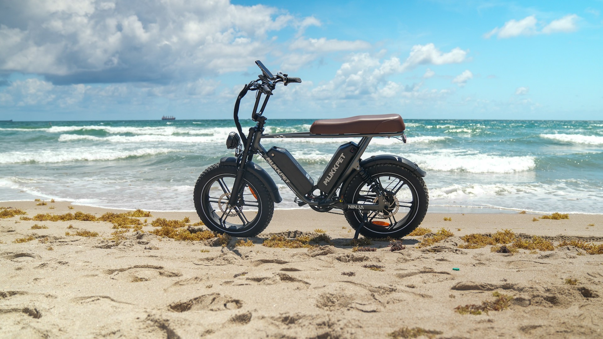 a scooter is parked on the beach near the ocean