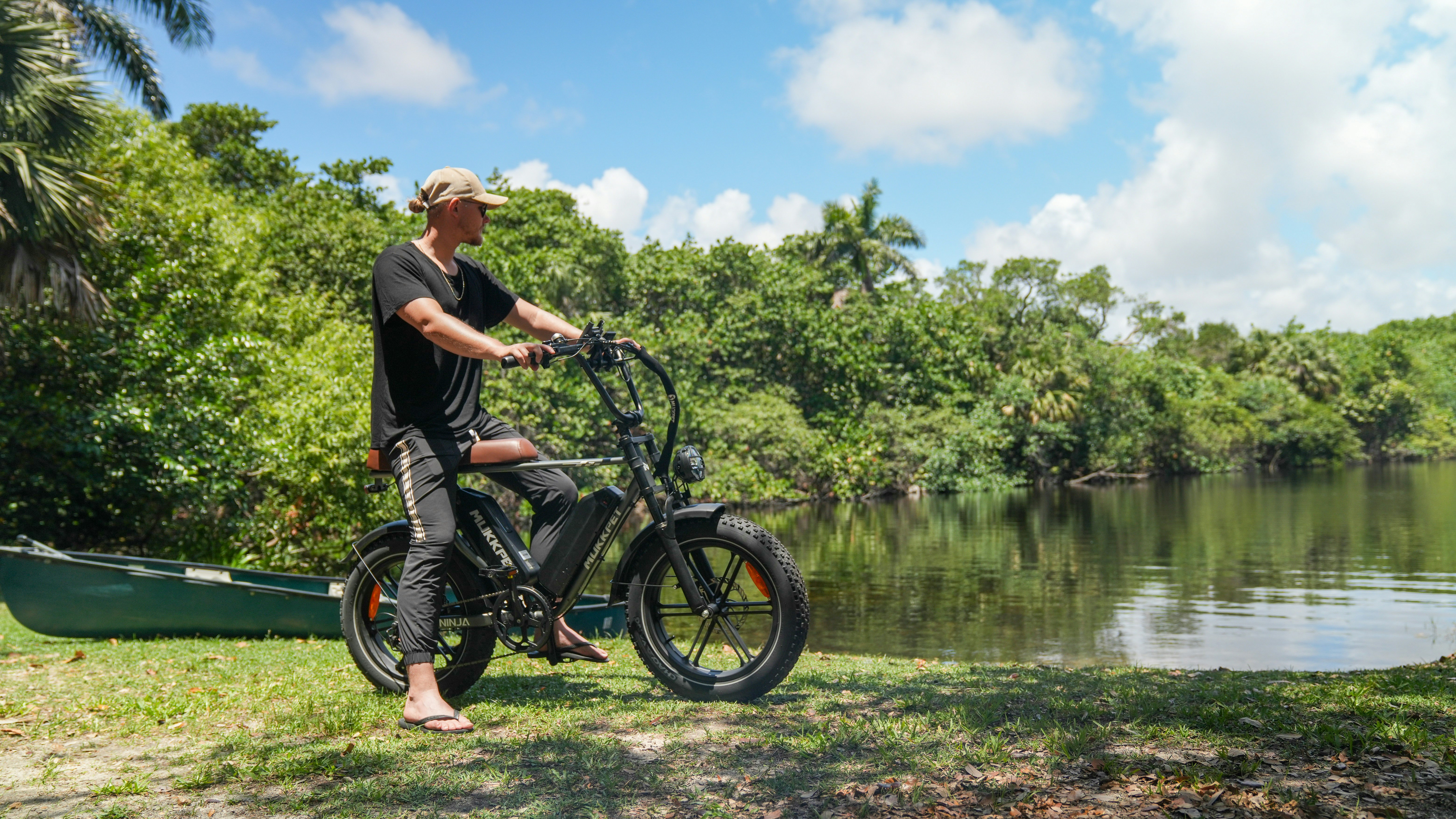 a man standing next to a bike next to a body of water