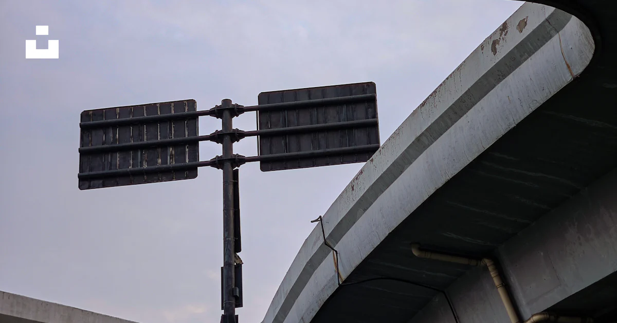 A street sign on a metal pole under a bridge photo – Free Road Image on ...