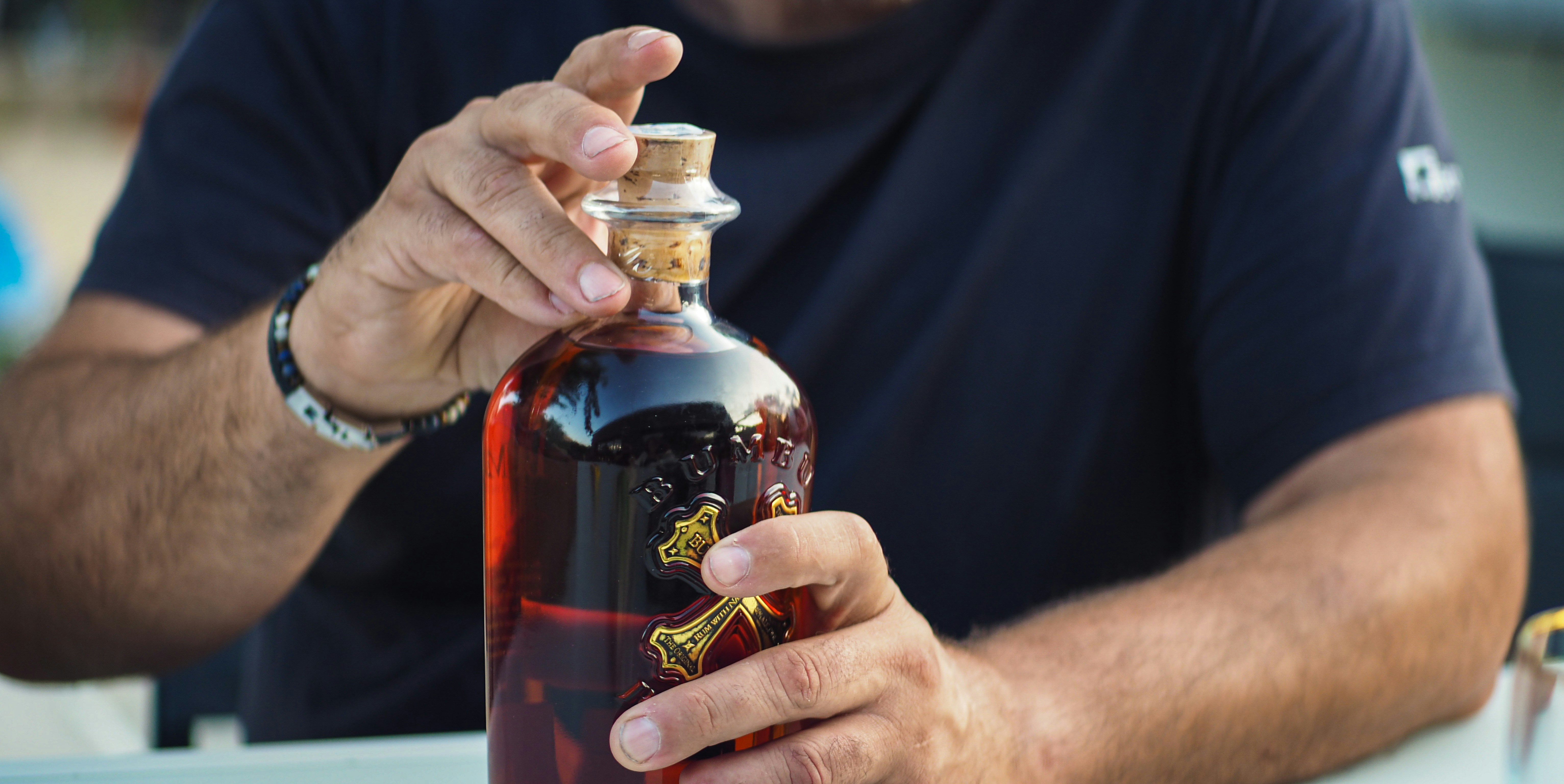a man is holding a bottle of liquor