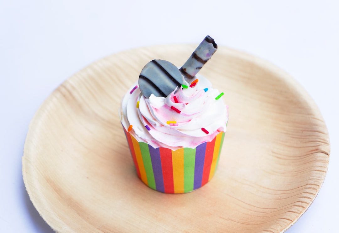 a cupcake with white frosting and sprinkles, Cupcake: Individual happiness in a tiny package, perfect for any occasion.