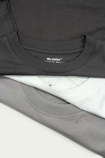 a pile of black and white shirts sitting on top of each other