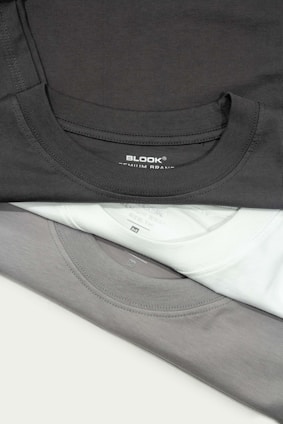 a pile of black and white shirts sitting on top of each other