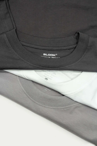 a pile of black and white shirts sitting on top of each other