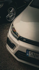 a close up of a white car parked in a parking lot
