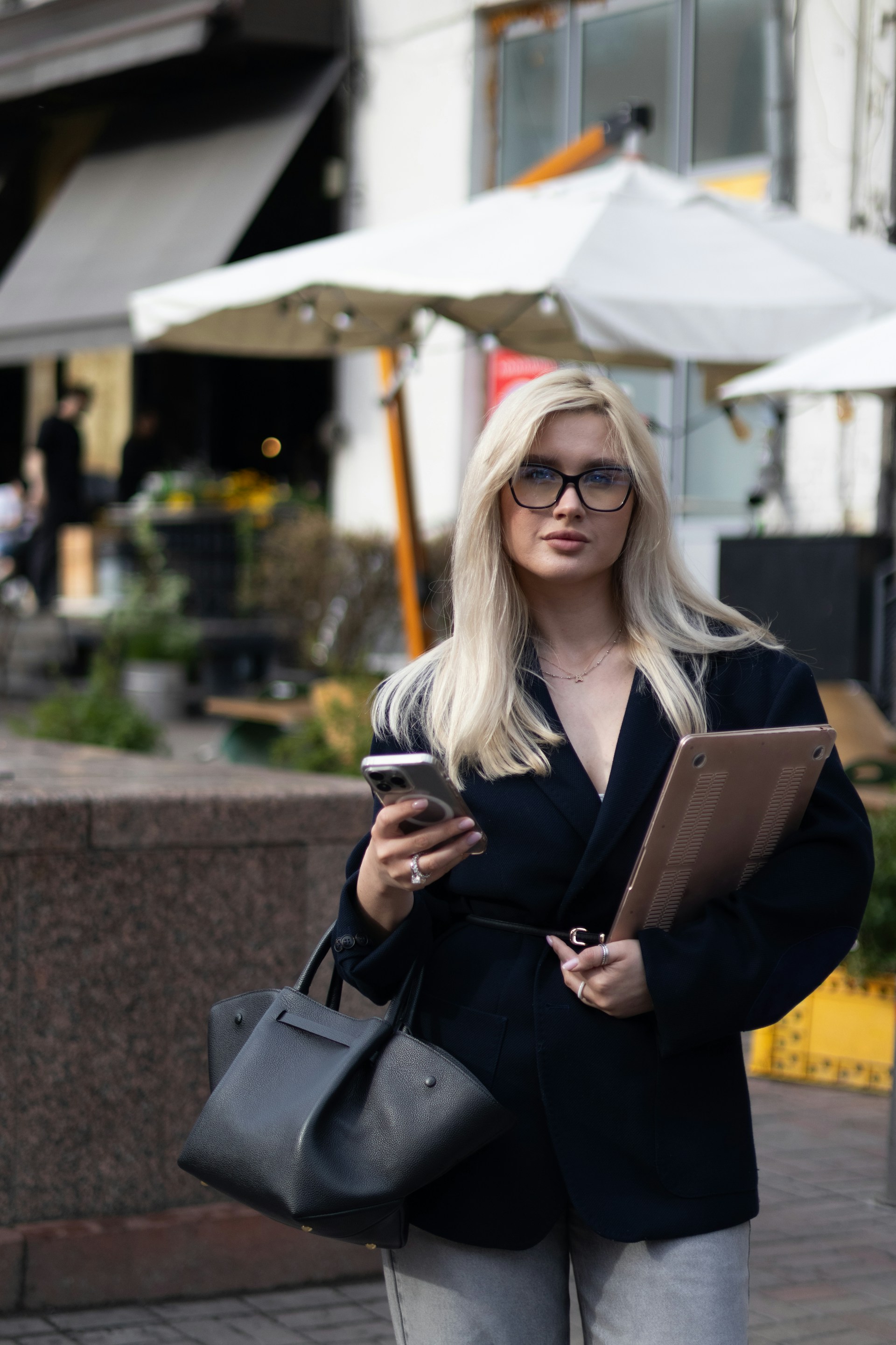 a woman in glasses is looking at her cell phone