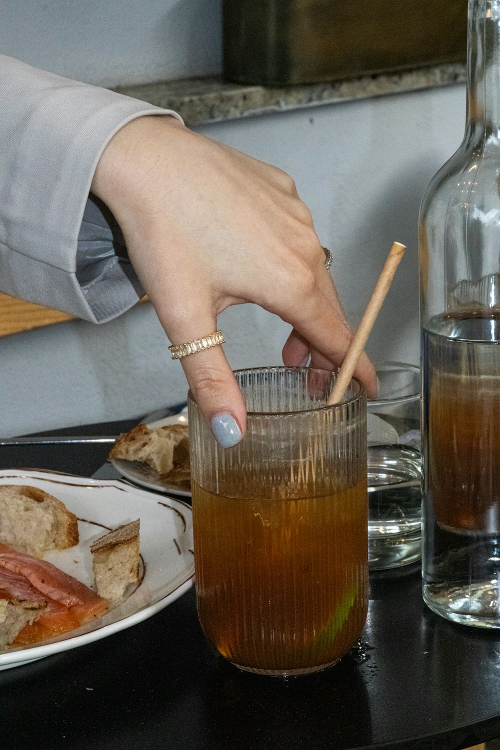  a person is holding a wooden stick over a drink