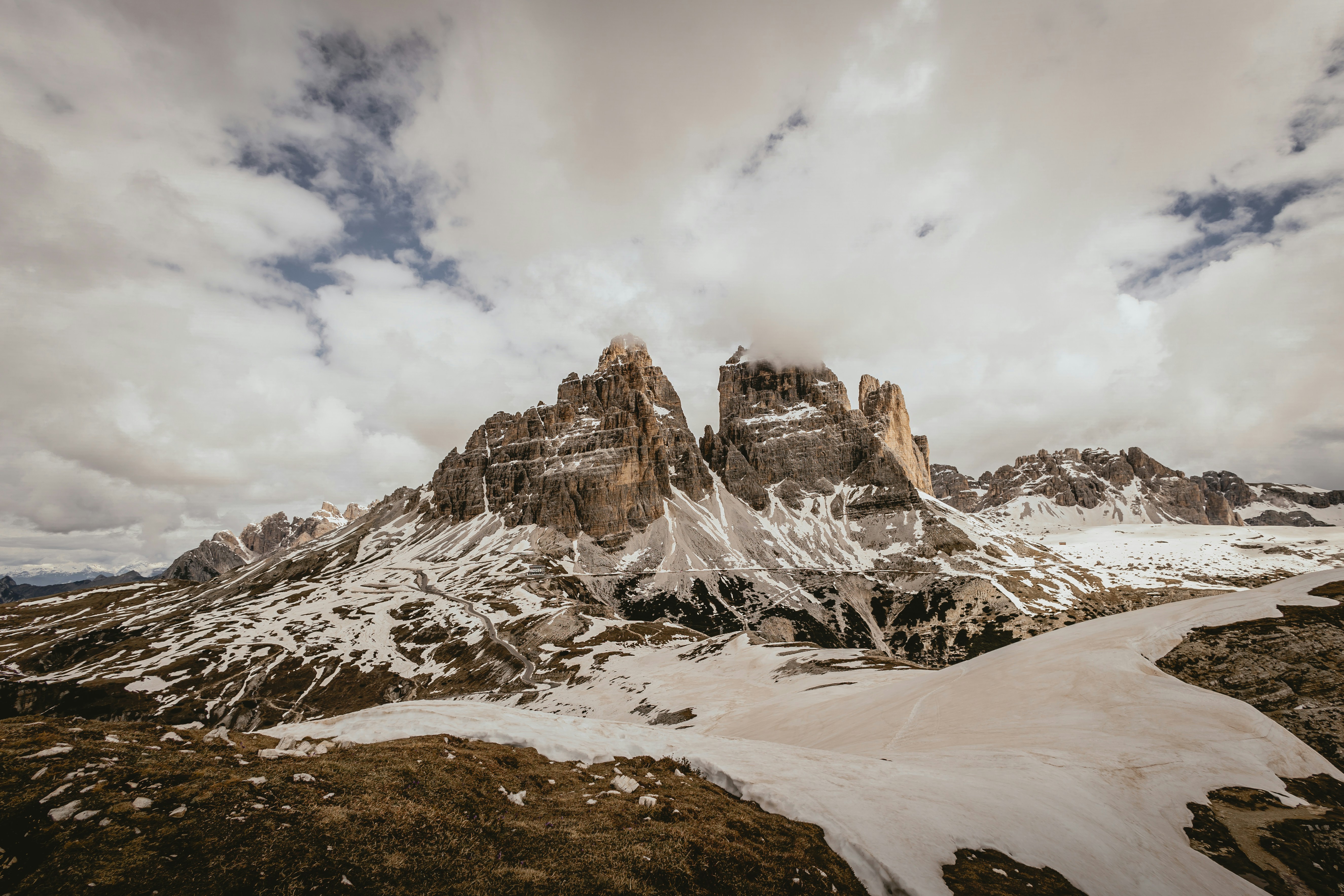 a snow covered mountain range under a cloudy sky