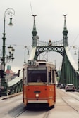 an orange trolley is going over a bridge