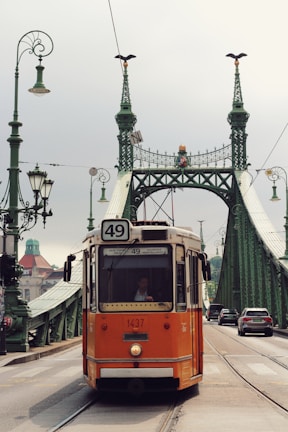 an orange trolley is going over a bridge