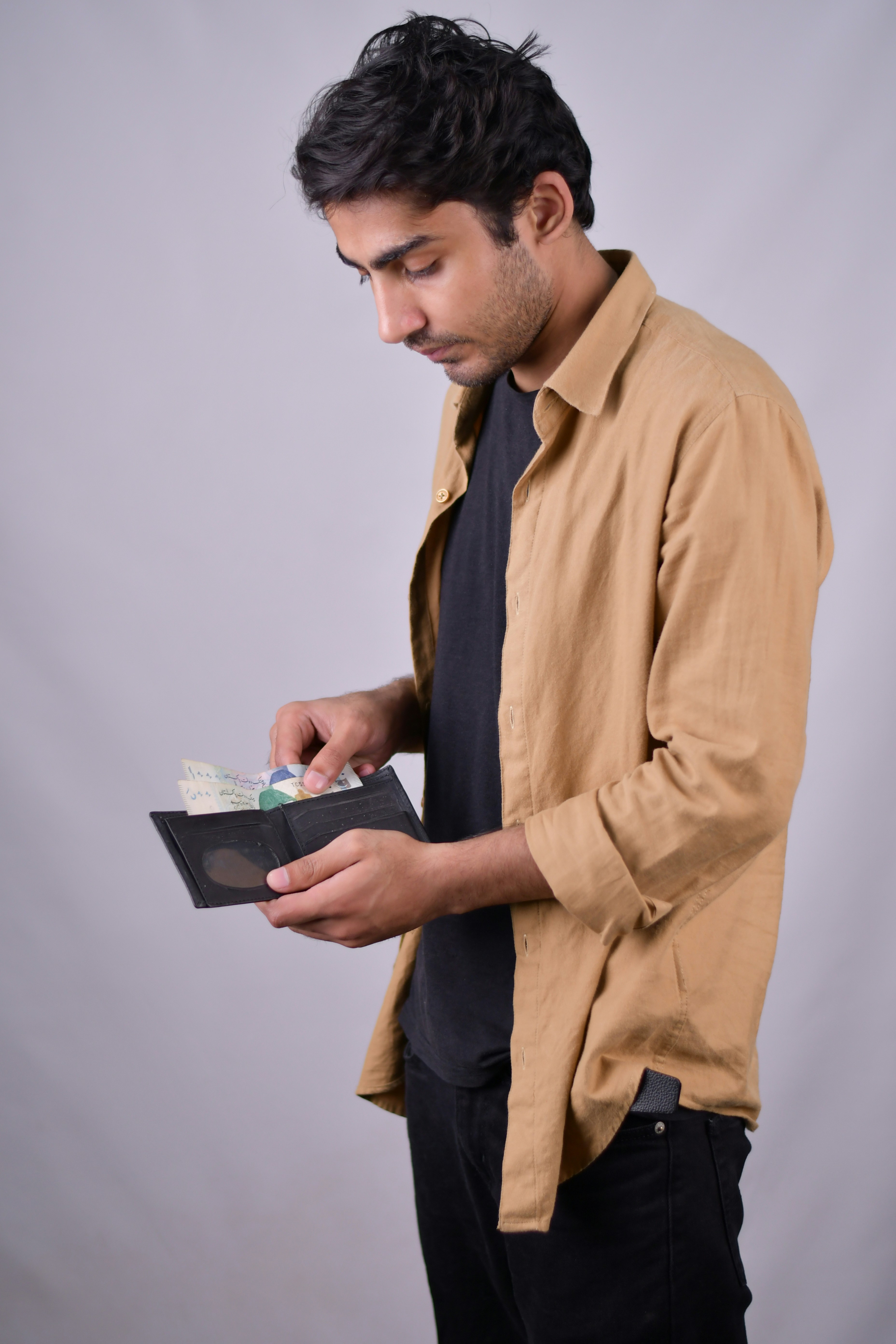 a man in a brown shirt is holding a folder