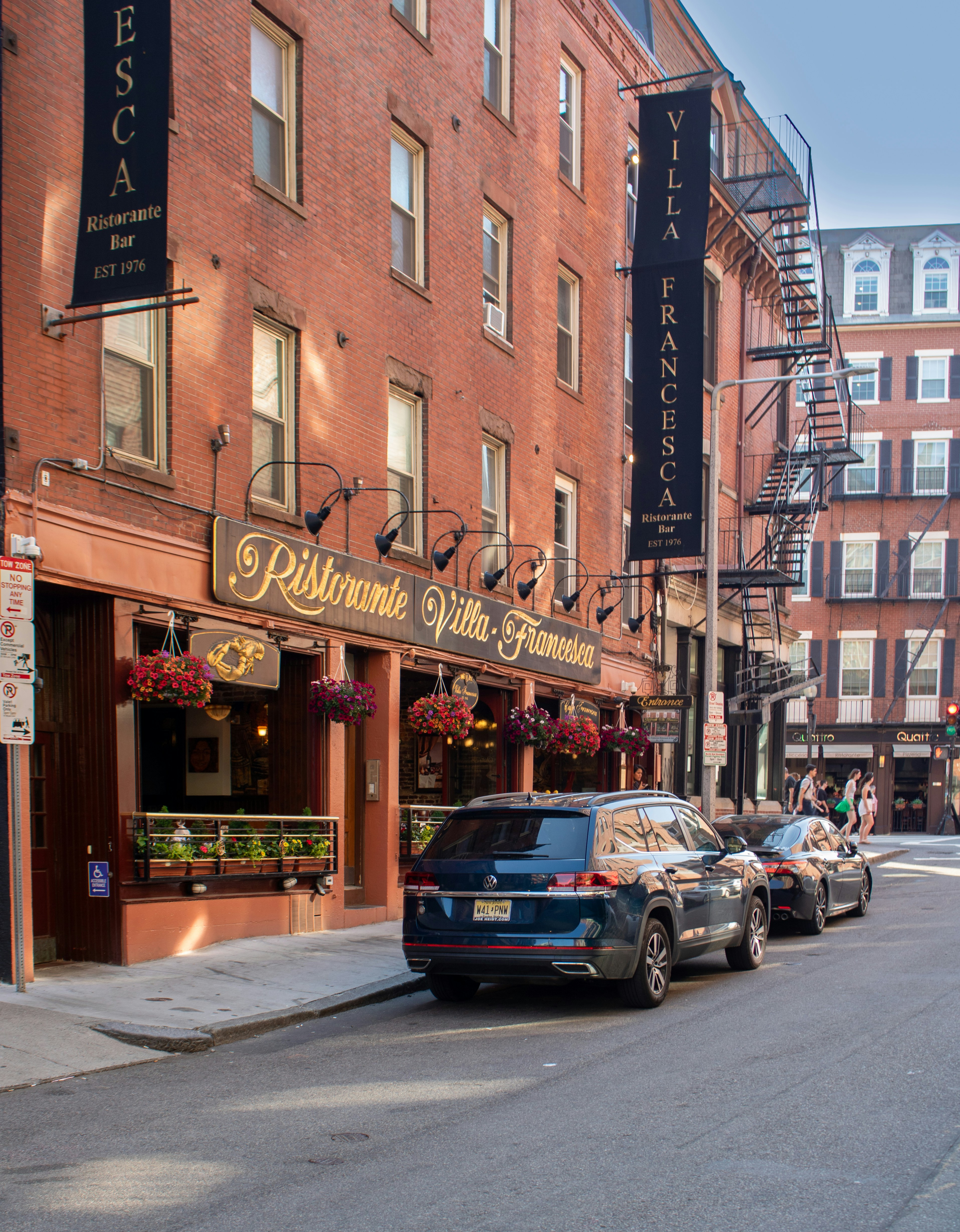 cars parked on the side of the road in front of a restaurant