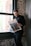a man standing in front of a window reading a newspaper