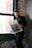 a man standing in front of a window reading a newspaper