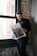 a man standing in front of a window reading a newspaper