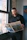 a man standing in front of a window reading a newspaper