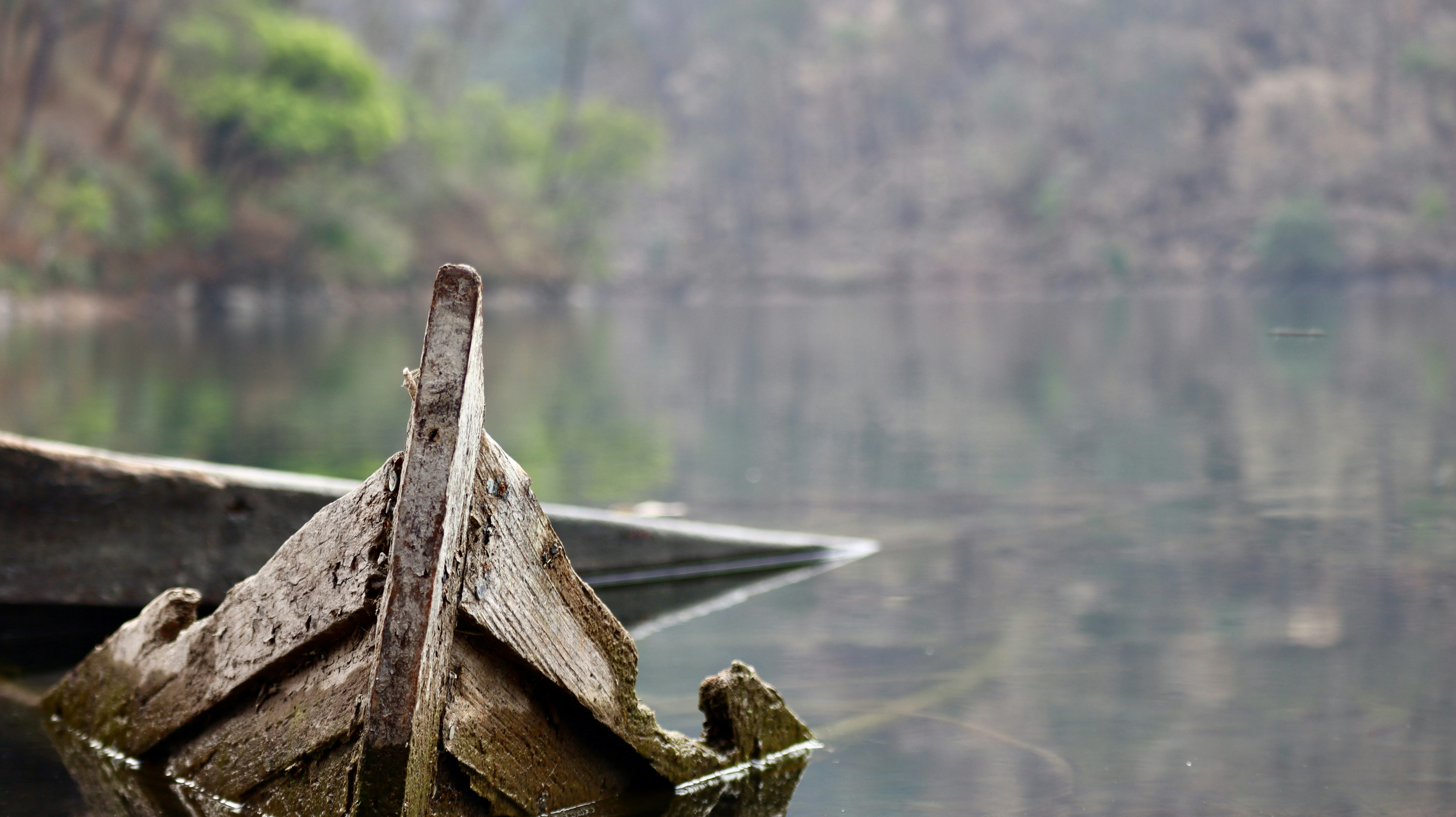a wooden boat floating on top of a lake