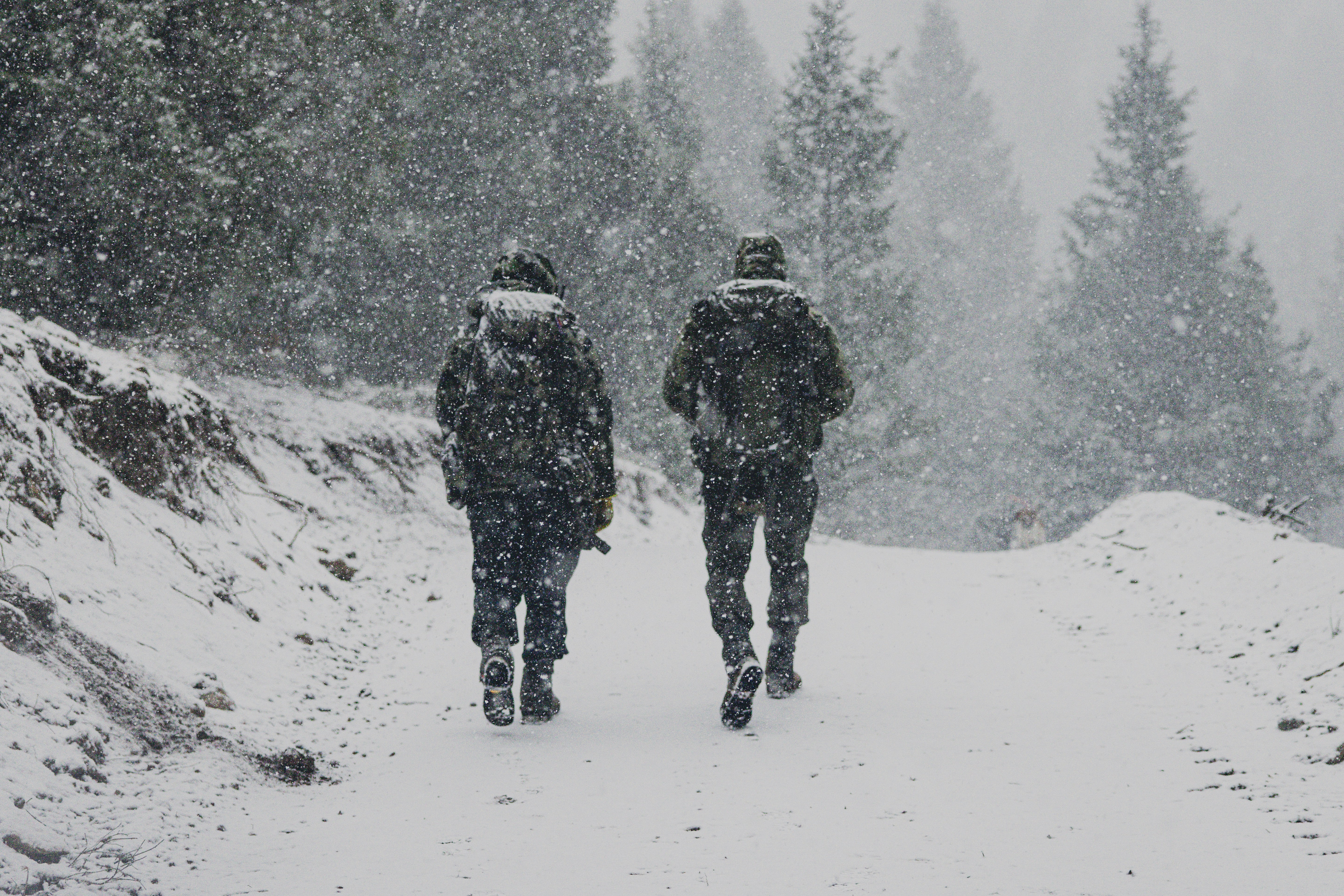 two people walking down a snow covered road