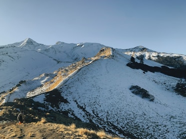 a snow covered mountain with a trail going up the side of it
