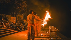 a couple of men standing in front of a fire