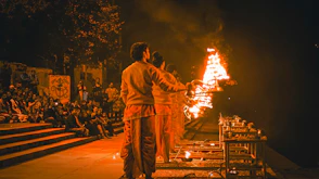 a couple of men standing in front of a fire
