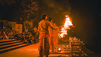 a couple of men standing in front of a fire