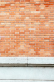 a man standing in front of a brick wall