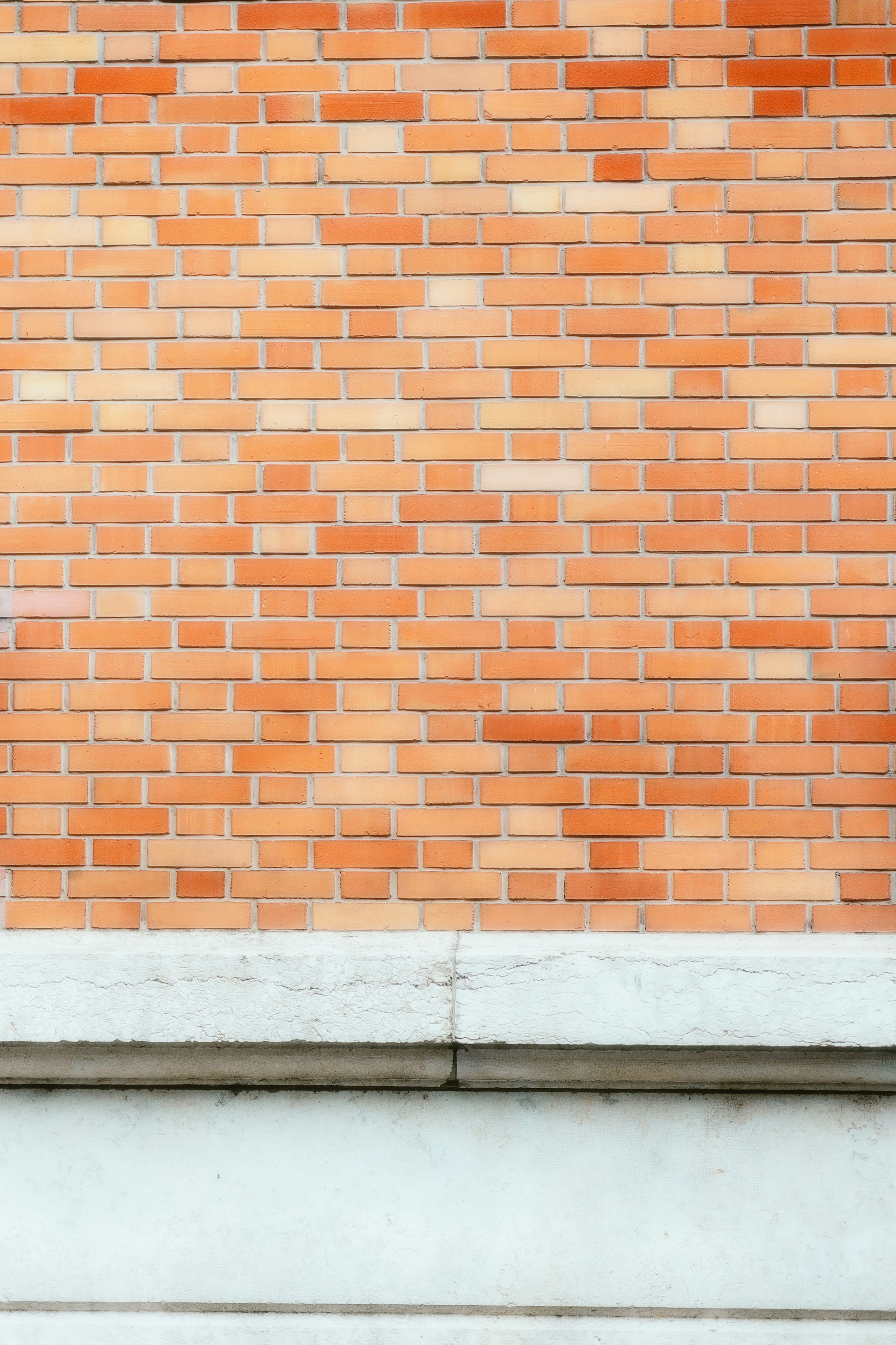 a man standing in front of a brick wall