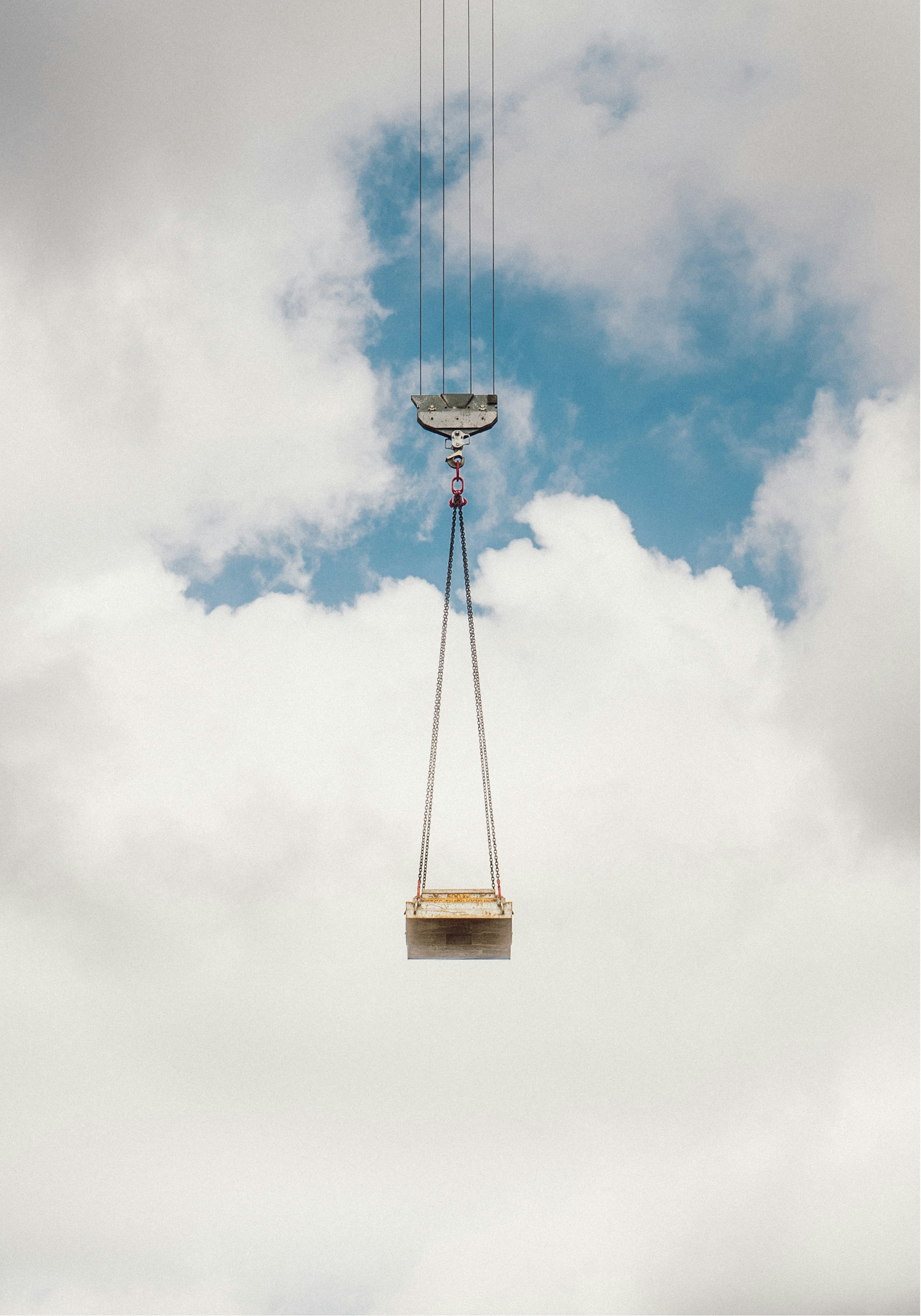 a crane is lifting a piece of equipment into the sky