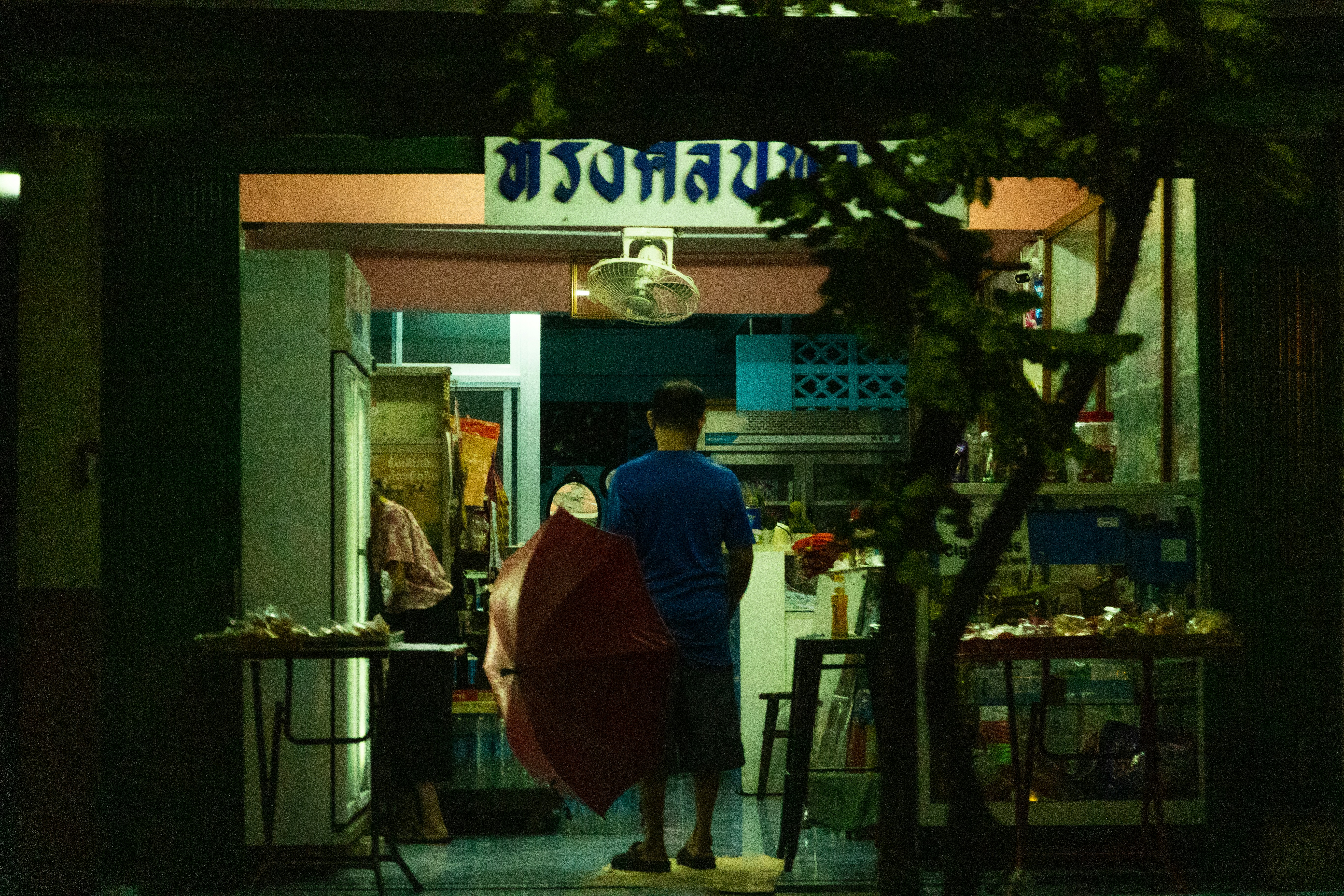 a man holding an umbrella in front of a store