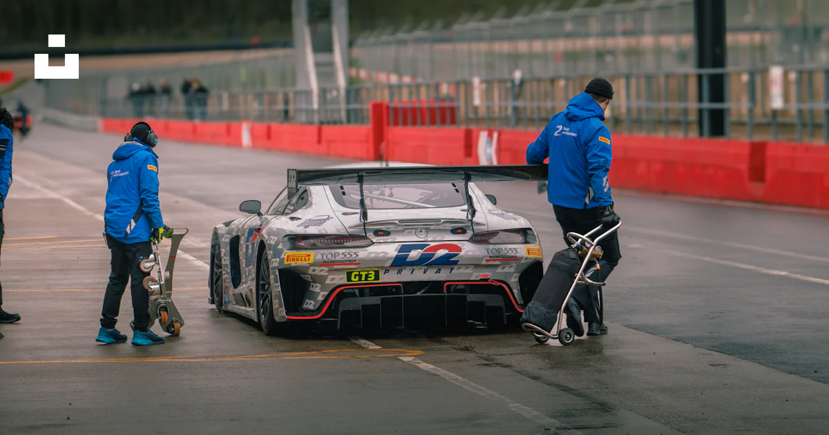 A man standing next to a race car on a race track photo – Free Mercedes ...
