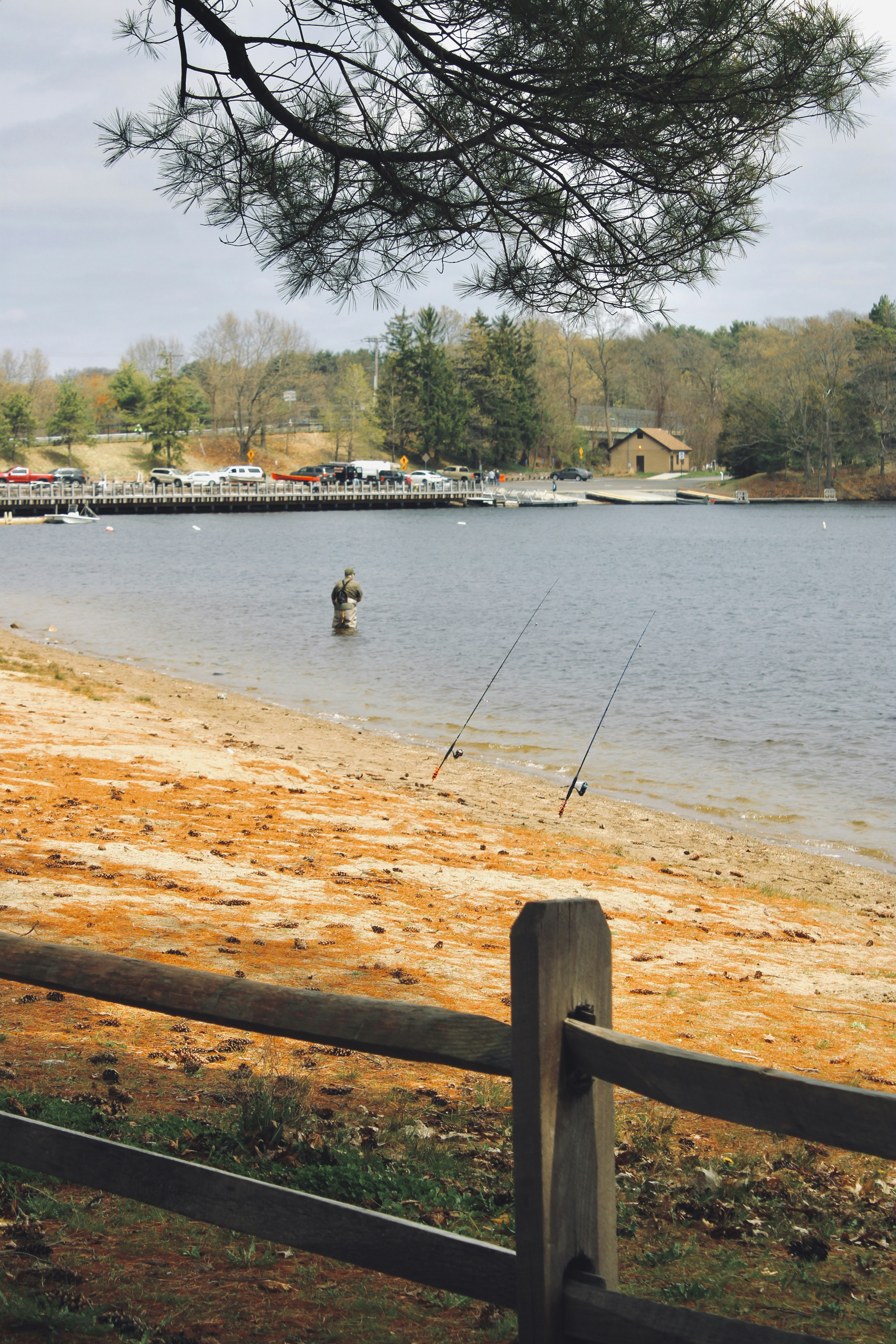 a man fishing on the shore of a lake