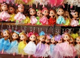 a bunch of dolls that are on a shelf