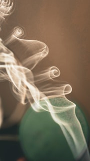 a blurry photo of a green object with smoke coming out of it