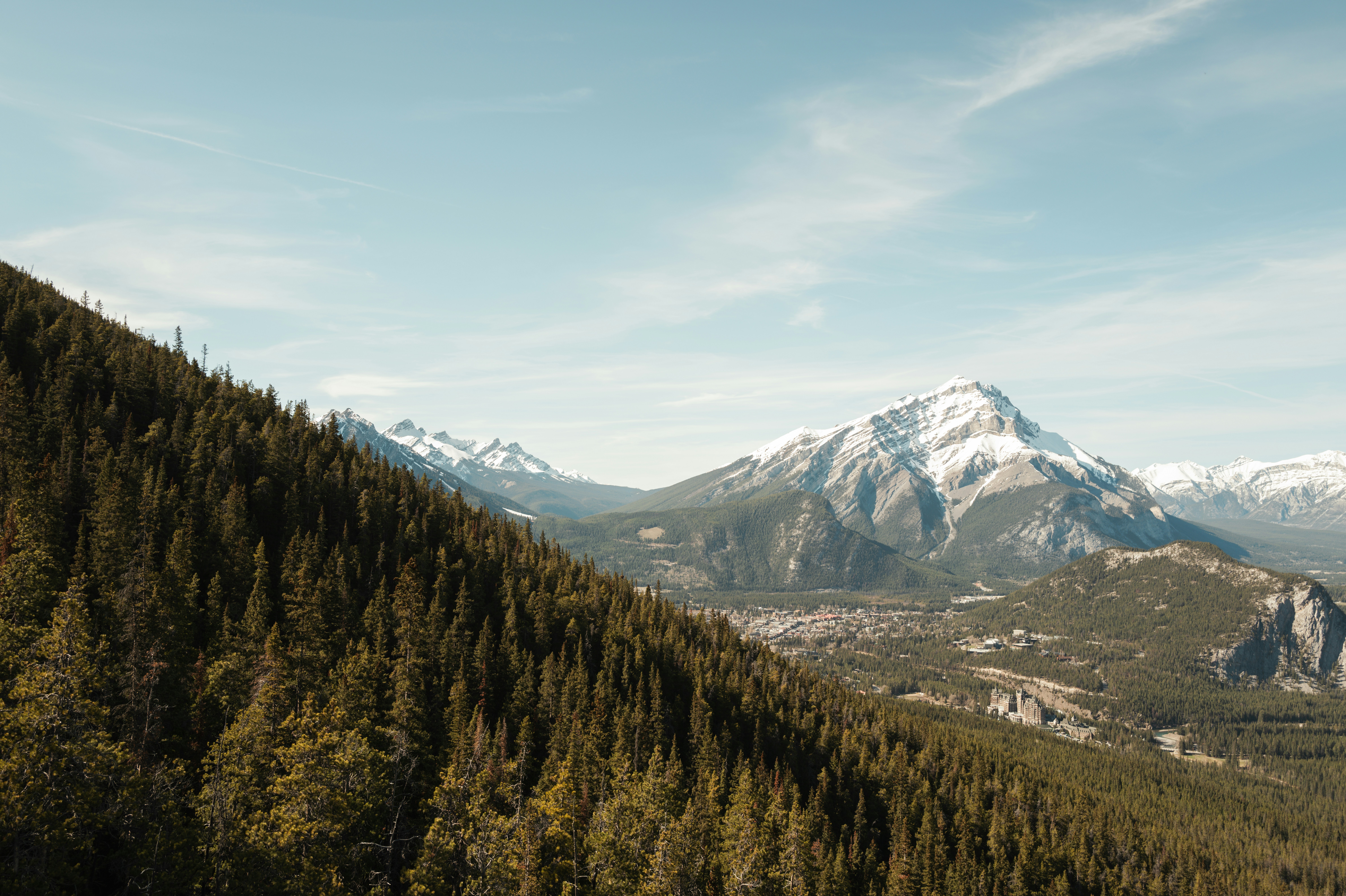 a view of a mountain range with trees and mountains in the background