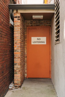 a red door with a no loitering sign on it