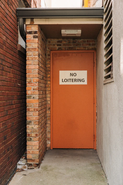 a red door with a no loitering sign on it
