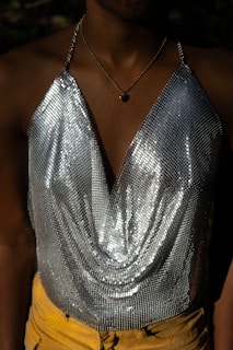 a close up of a person wearing a silver top