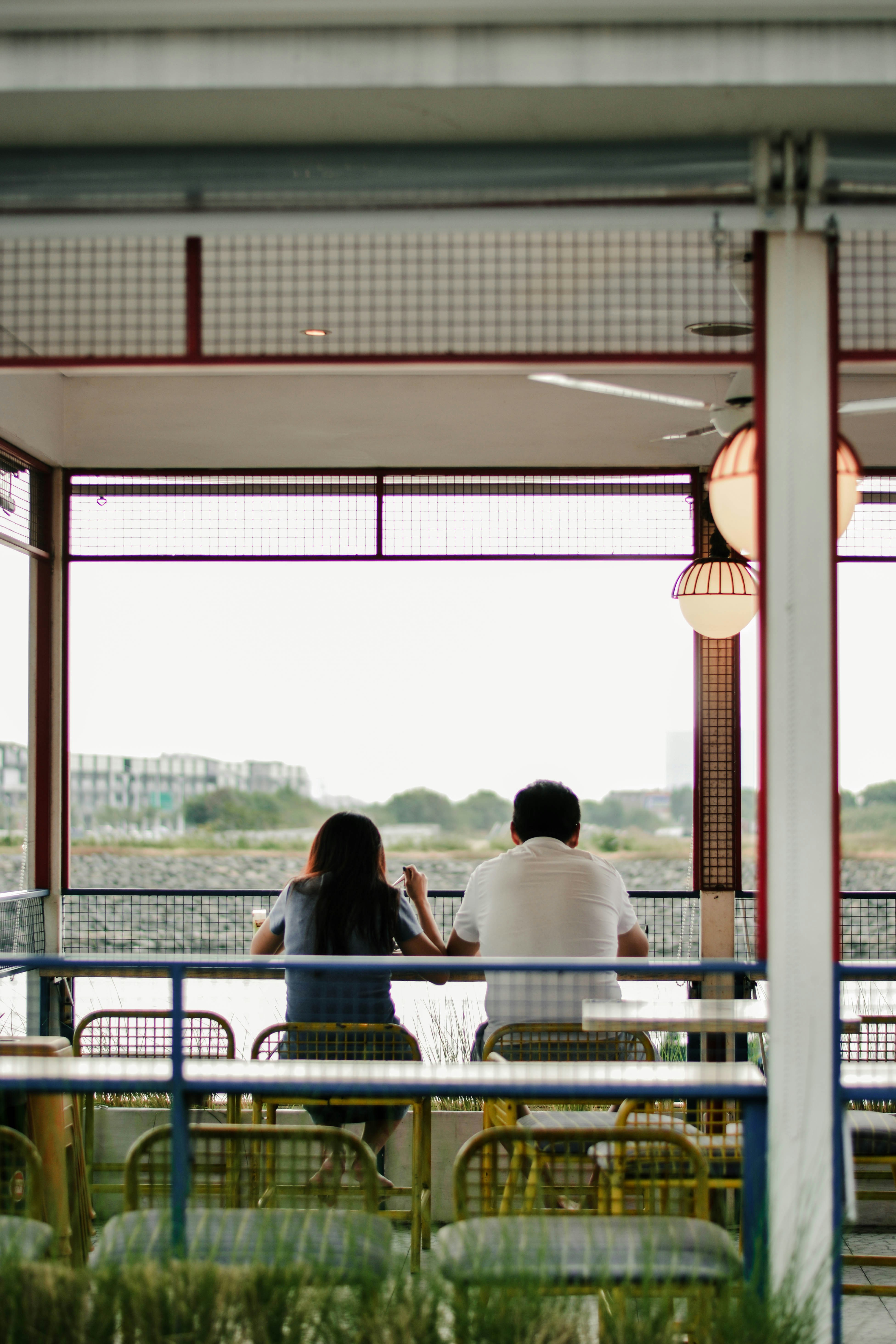 a couple of people sitting at a table next to each other