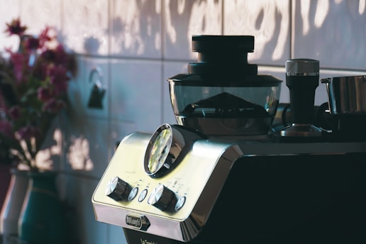 a blender sitting on top of a counter next to a vase of flowers