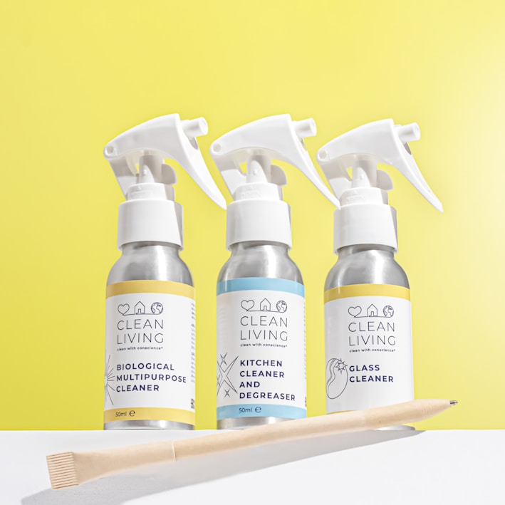 three bottles of cleaning products next to a toothbrush