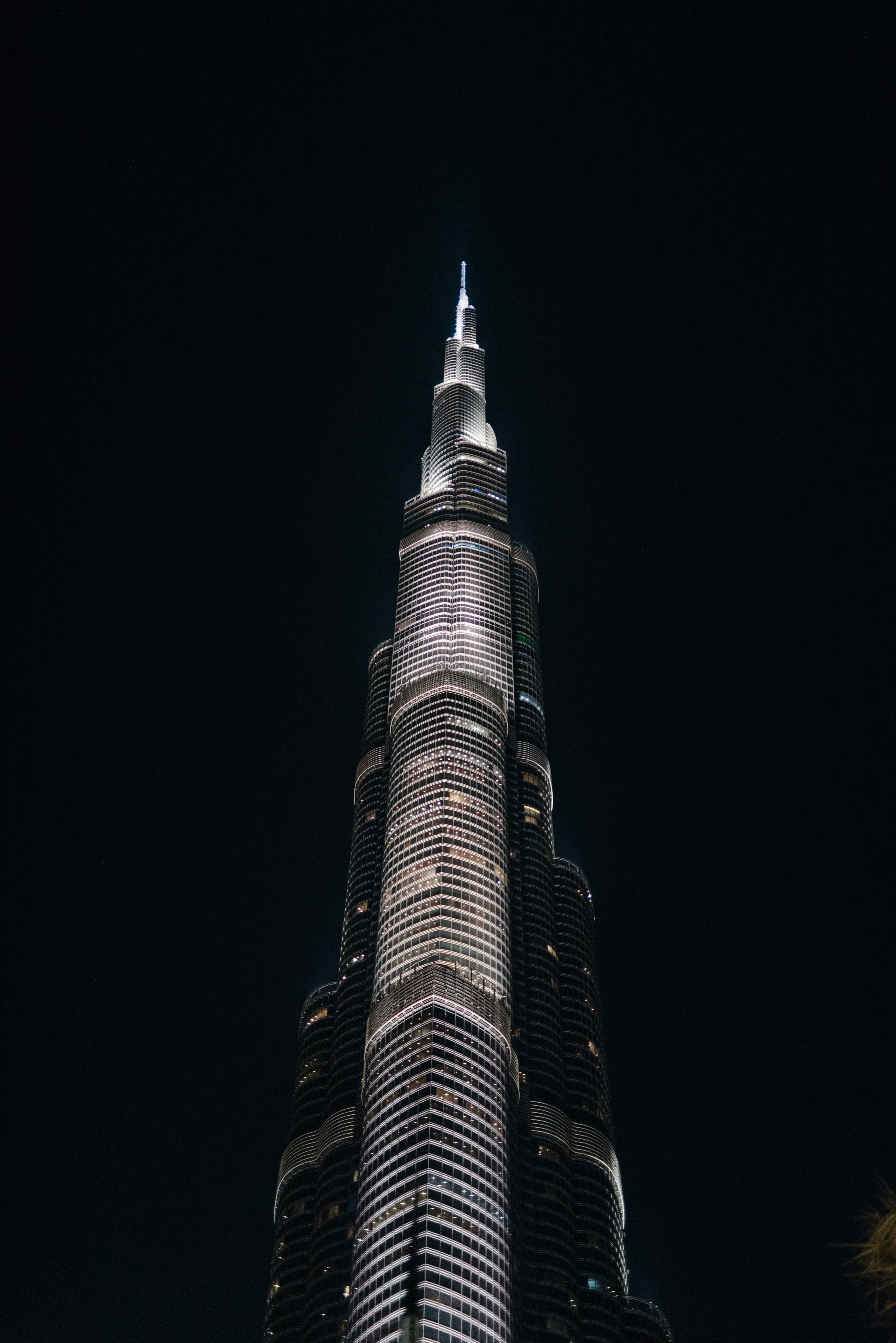 ein sehr hohes Gebäude, das nachts beleuchtet ist