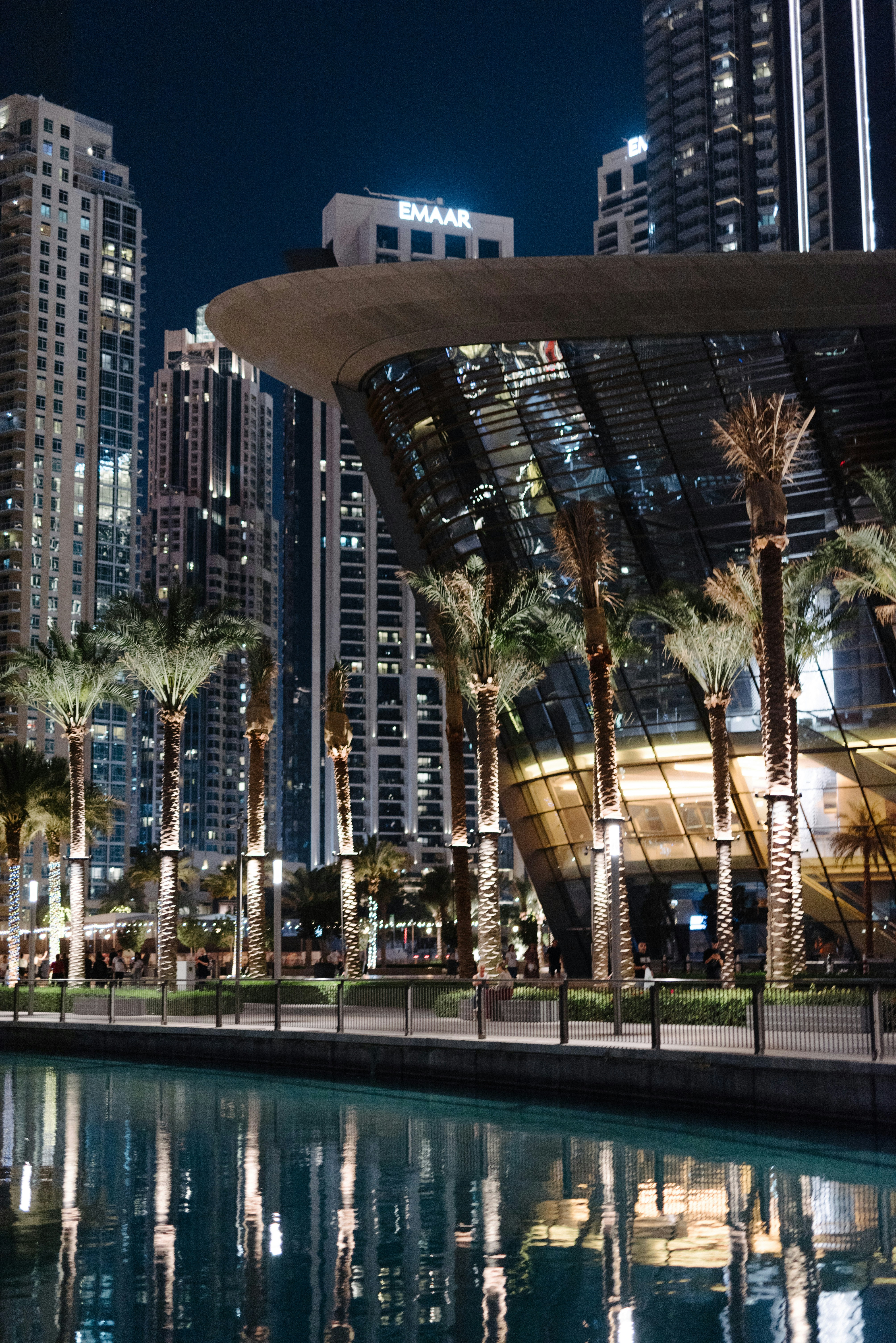Eine Stadt bei Nacht mit hohen Gebäuden und Palmen