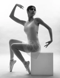 a black and white photo of a woman in a leotard