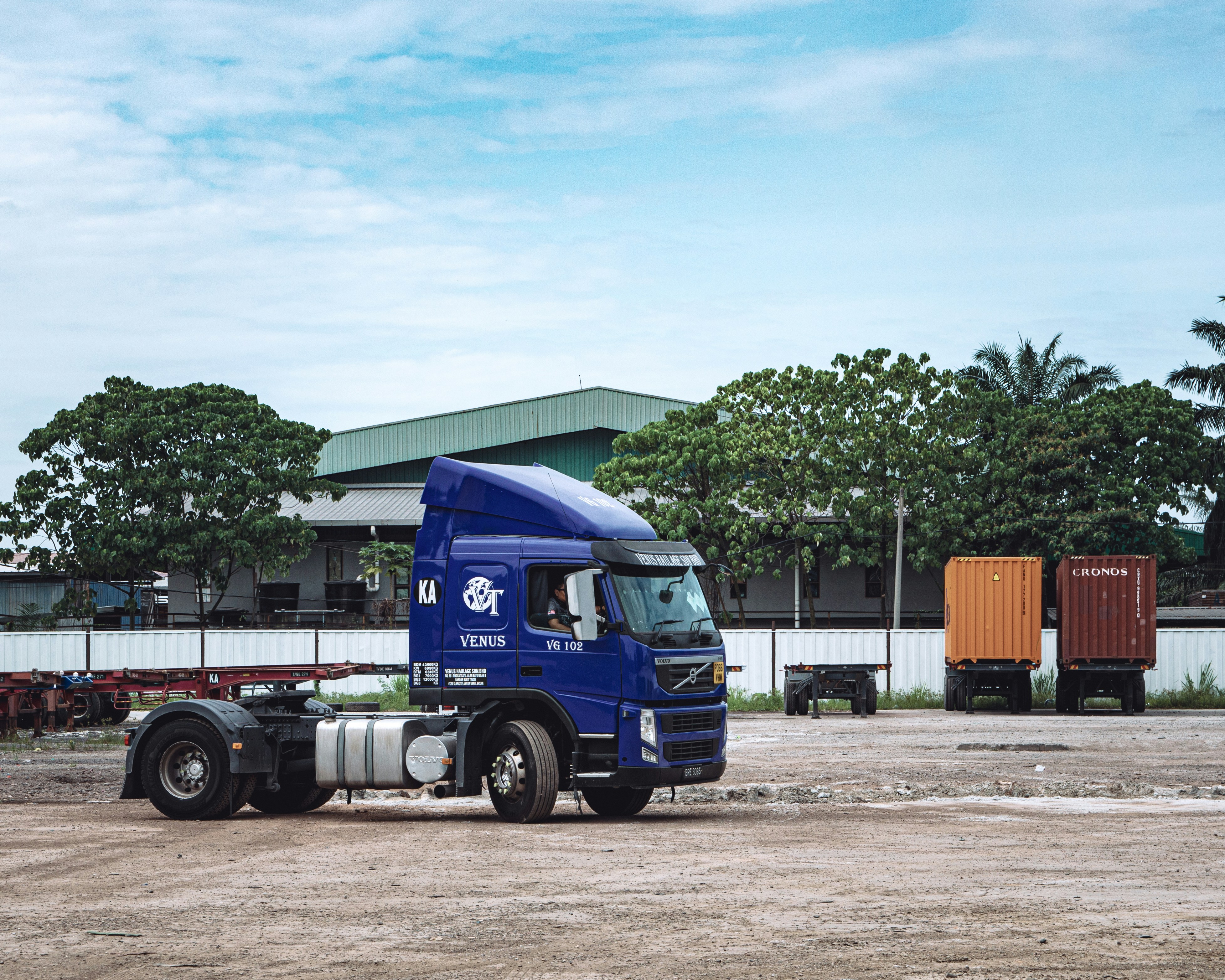 a blue semi truck parked in front of a building