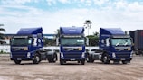 a couple of blue trucks parked next to each other