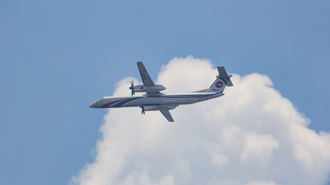 a plane flying in the sky with a cloud in the background, Biman Bangladesh Airlines Dash 8 Q400.
