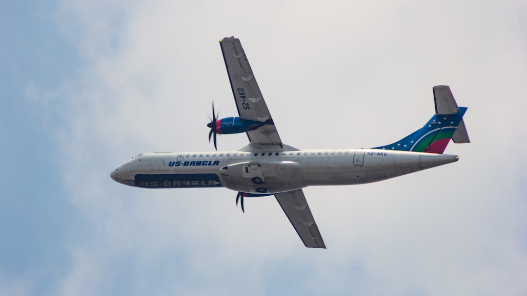 a large passenger jet flying through a cloudy blue sky, US-Bangla Airlines ATR 72-600 flying