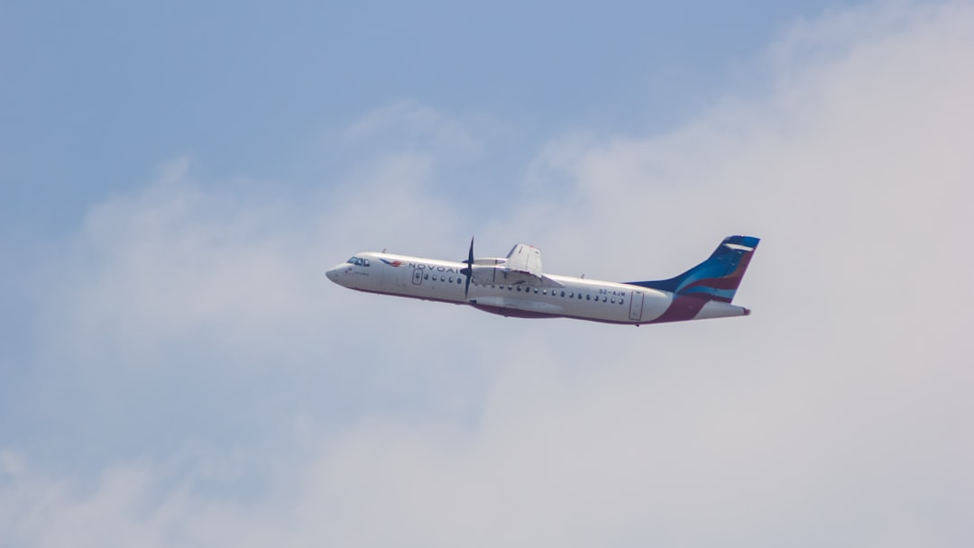 a large passenger jet flying through a cloudy blue sky,