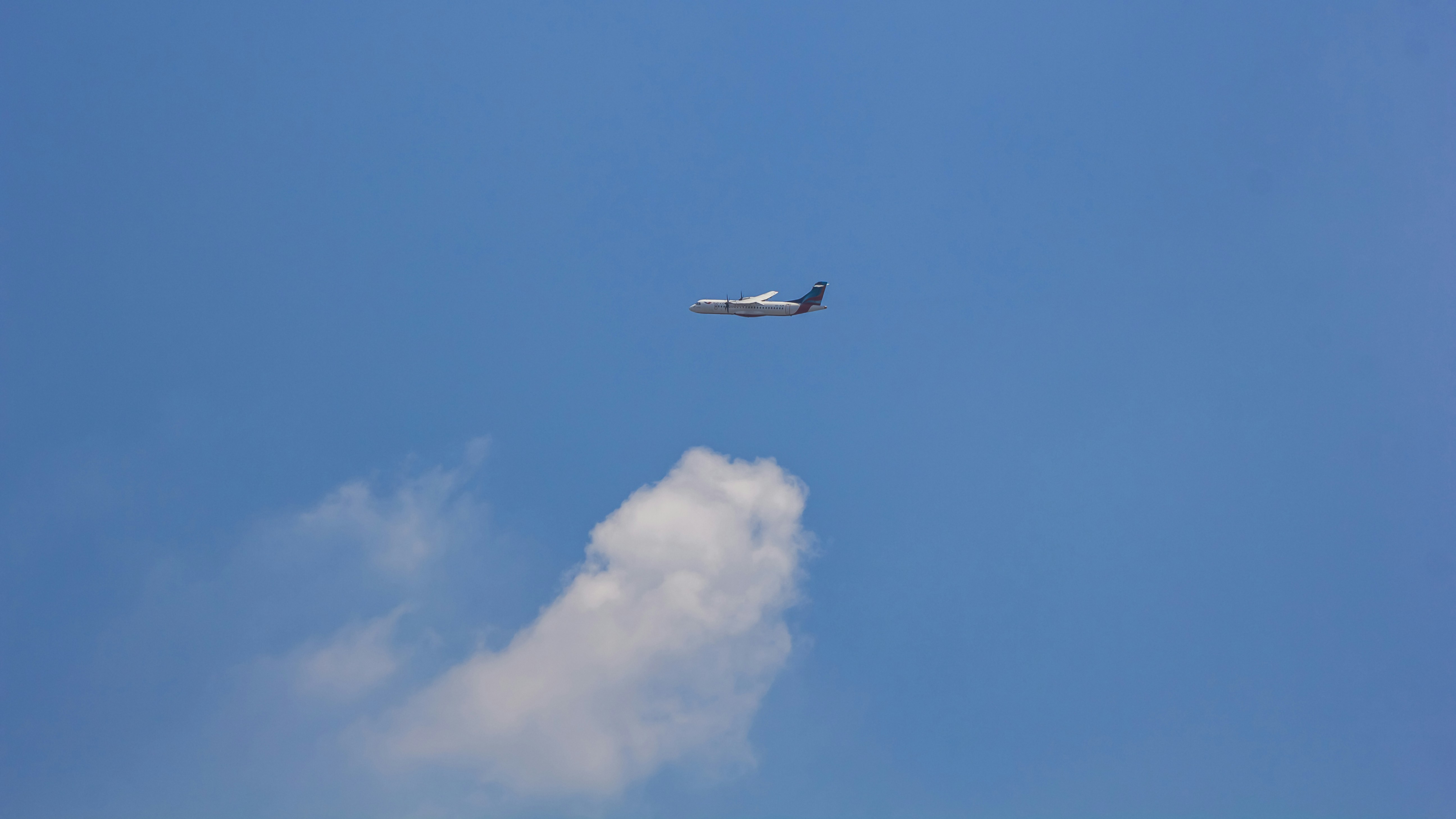 an airplane is flying in the blue sky, ATR72 flying above clouds
